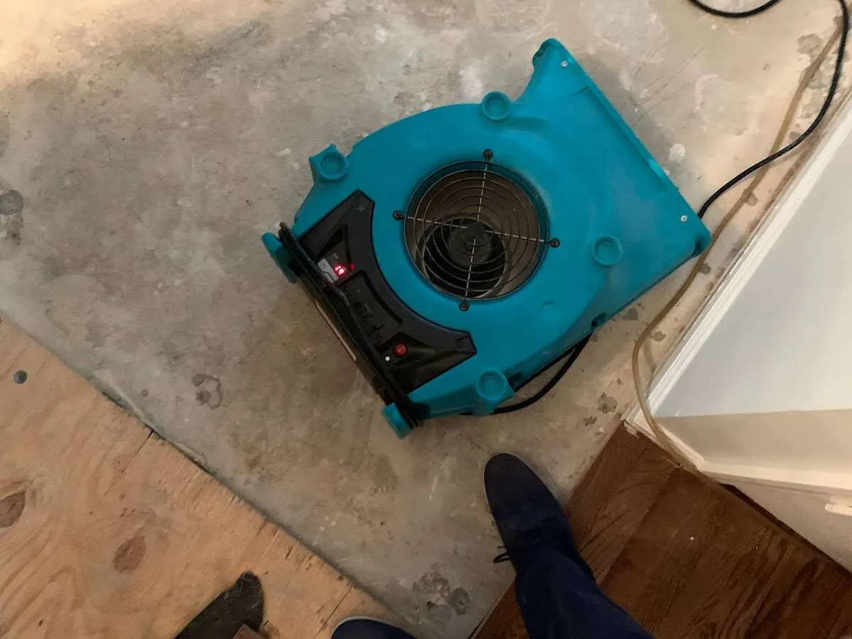 Air mover drying subfloor during Leak Detection & Repair in Houlton